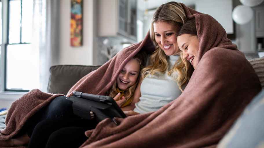 mom and children cozy under a blanket 
