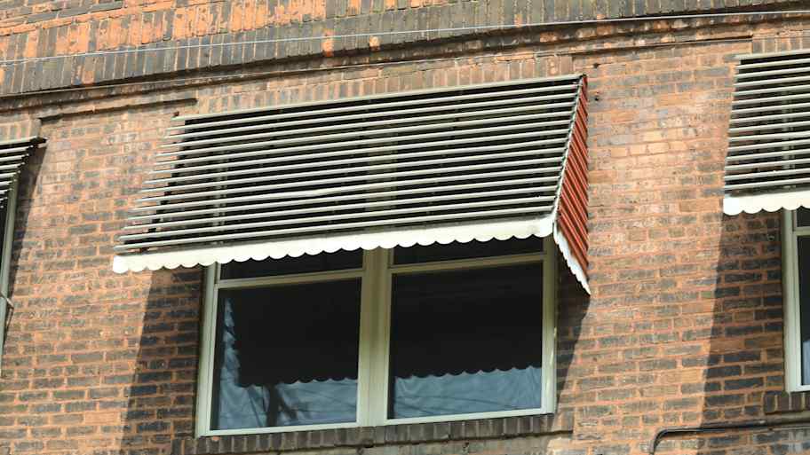 An awning window on a brick house 
