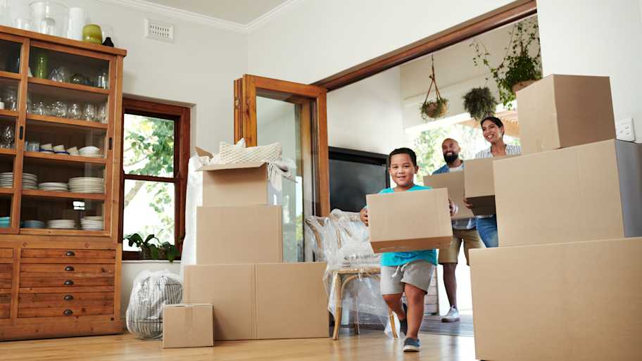 Family walking into new home with boxes