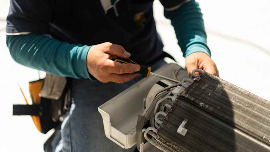 man repairing ac coil