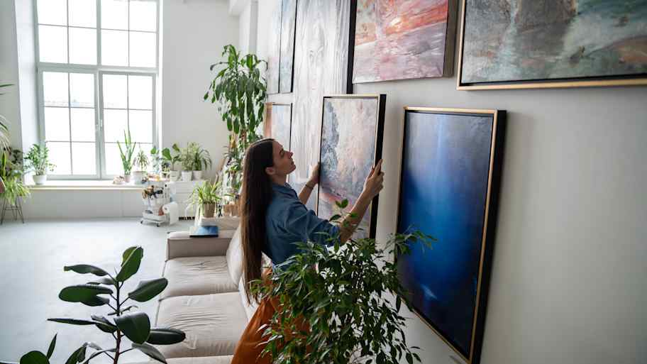 woman making gallery wall in home