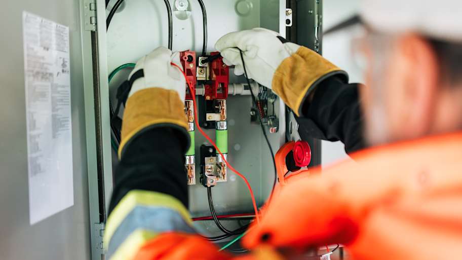 An electrician installing an electrical box