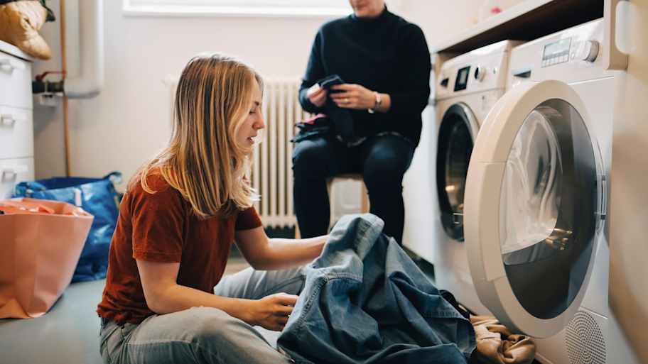Woman putting clothes in washing machine