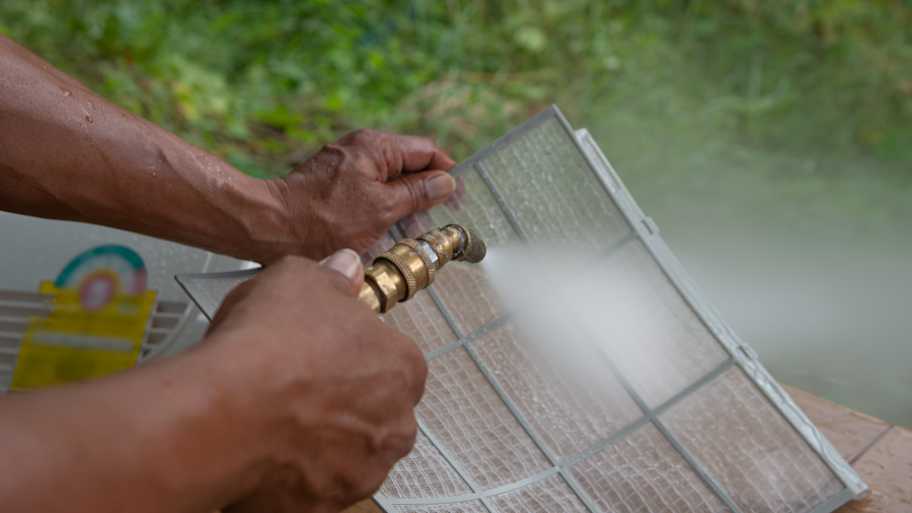man cleaning mini split filter