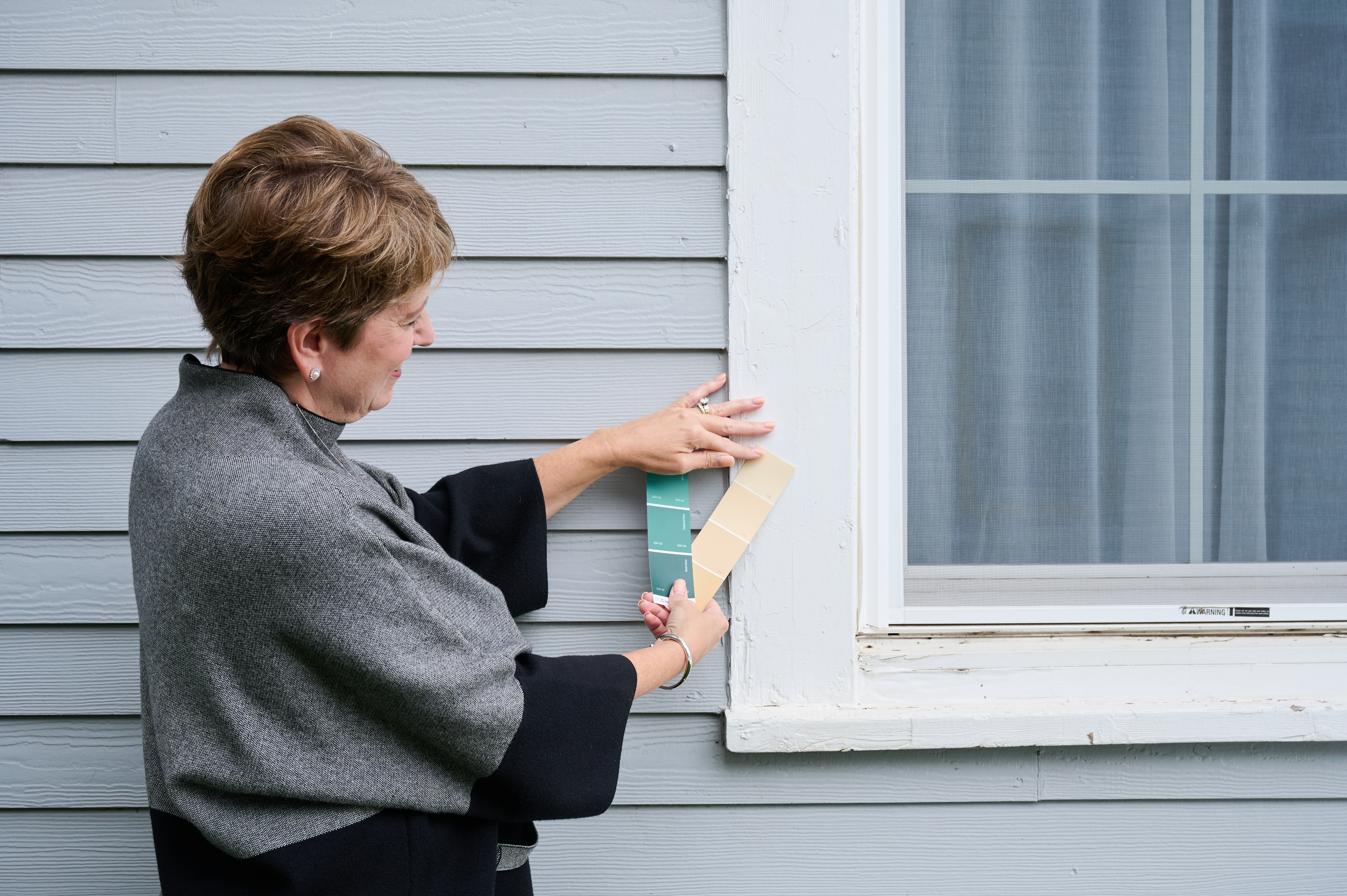 Angie Hicks picking color swatches for the window trim of this home