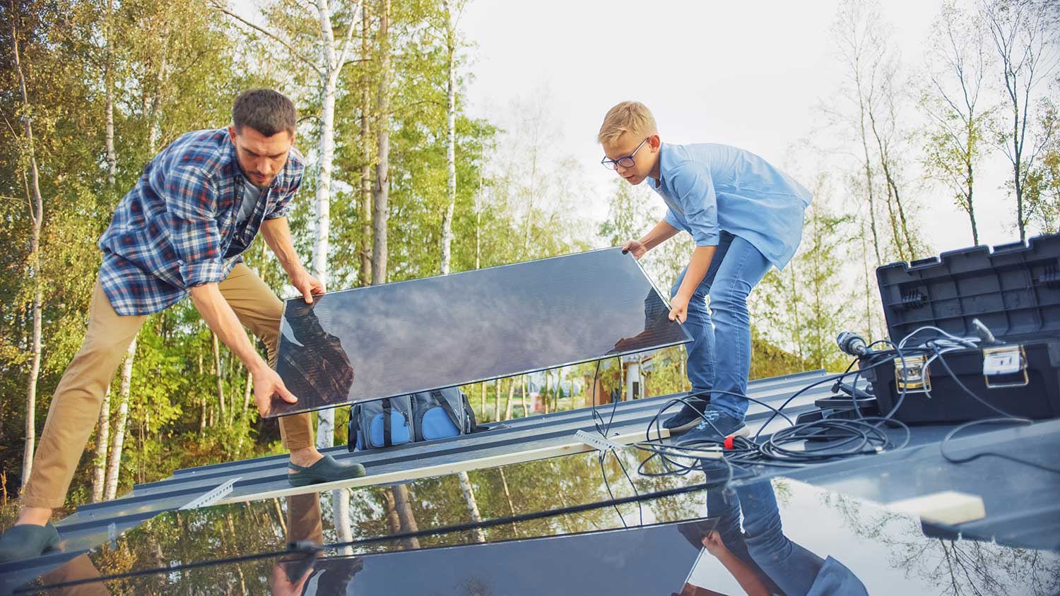 Father and son installing solar panels on the roof