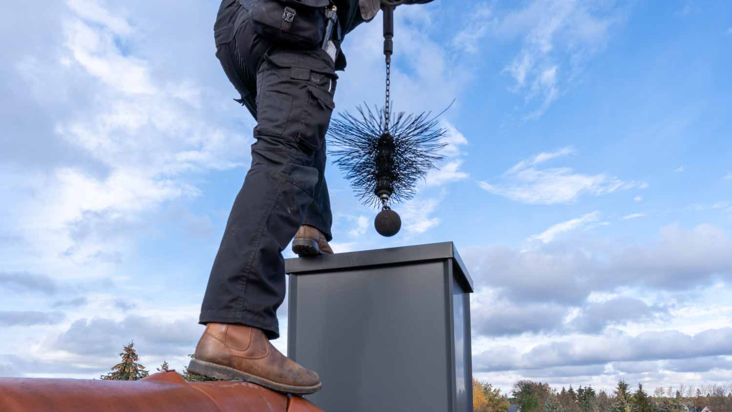 Chimney sweep cleaning a chimney