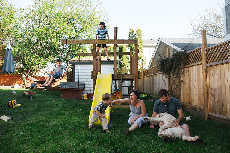 Family playing on a backyard playground and swing set