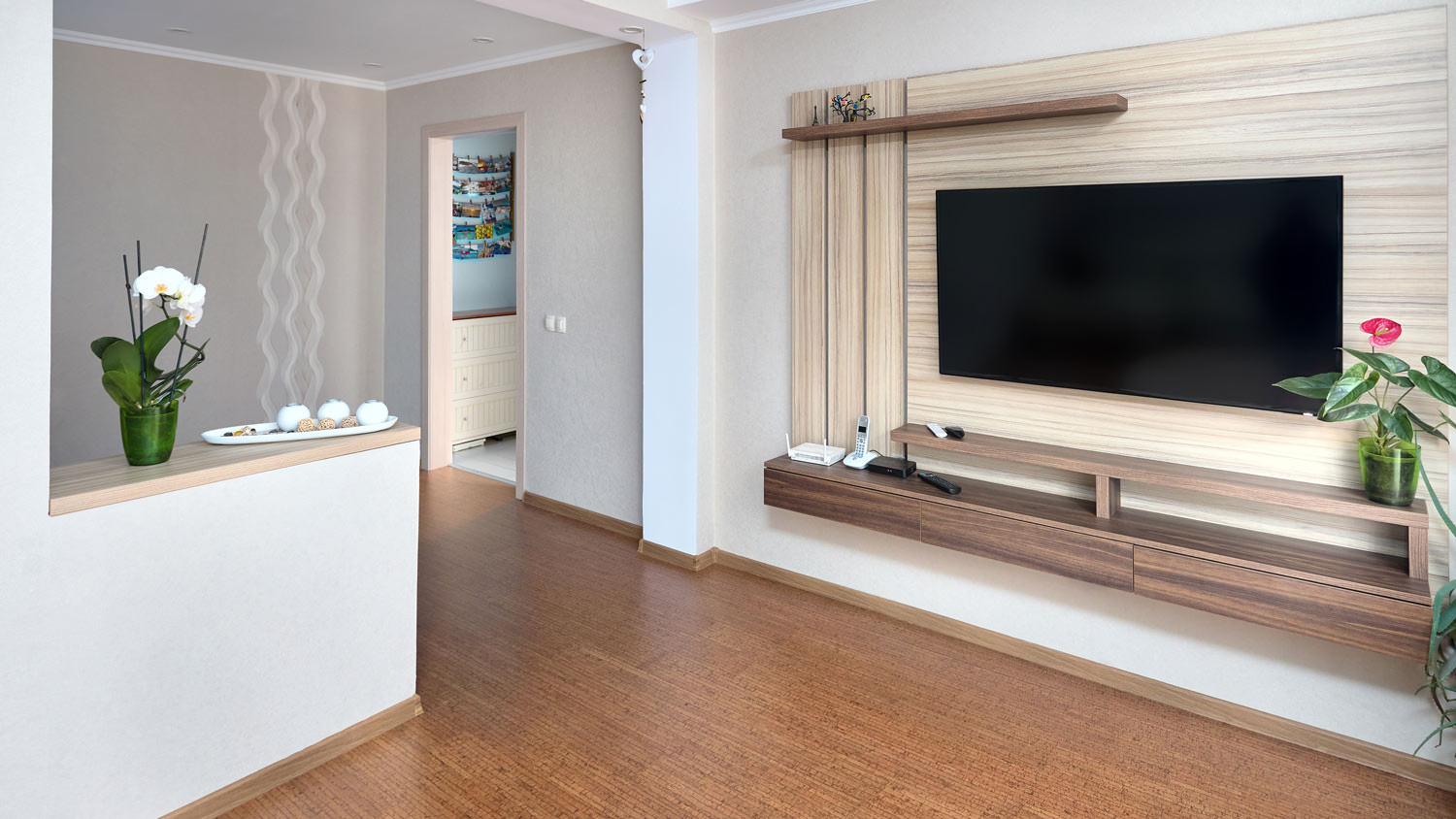 A living room with large tv and cork floorboards