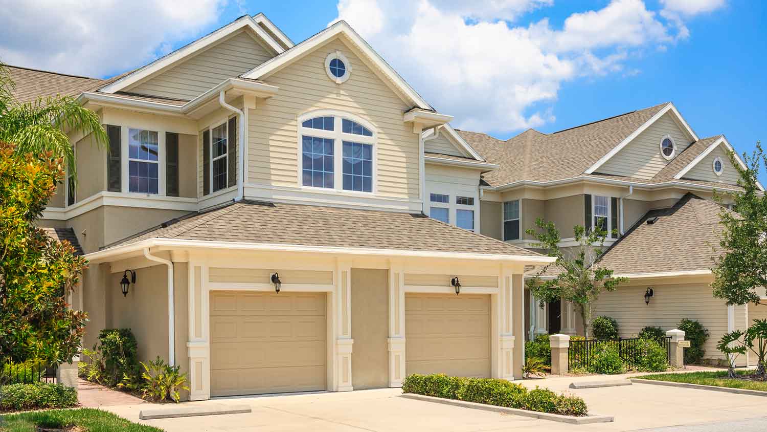 Duplex homes with beige garage doors