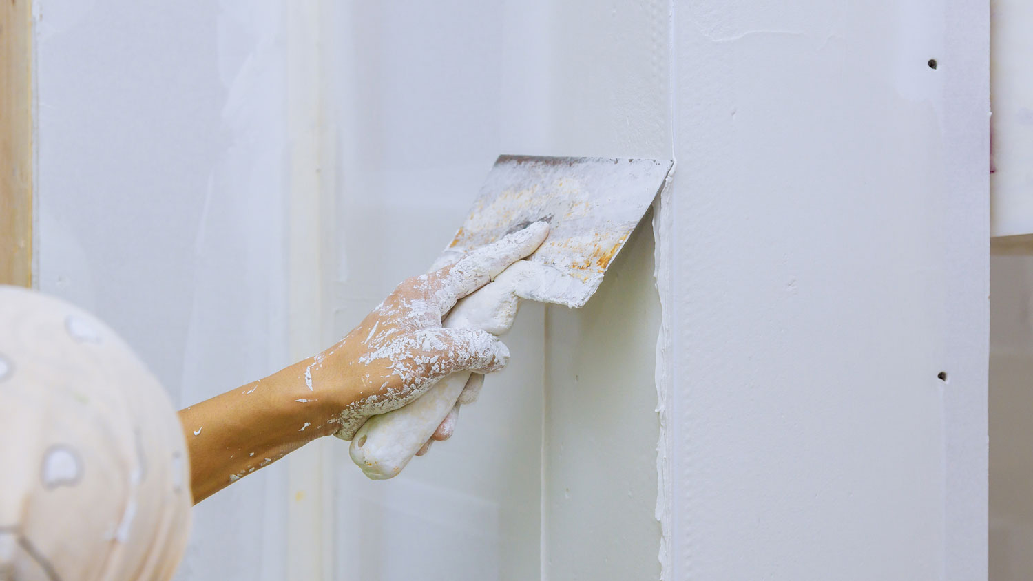 Close-up of a person patching a drywall