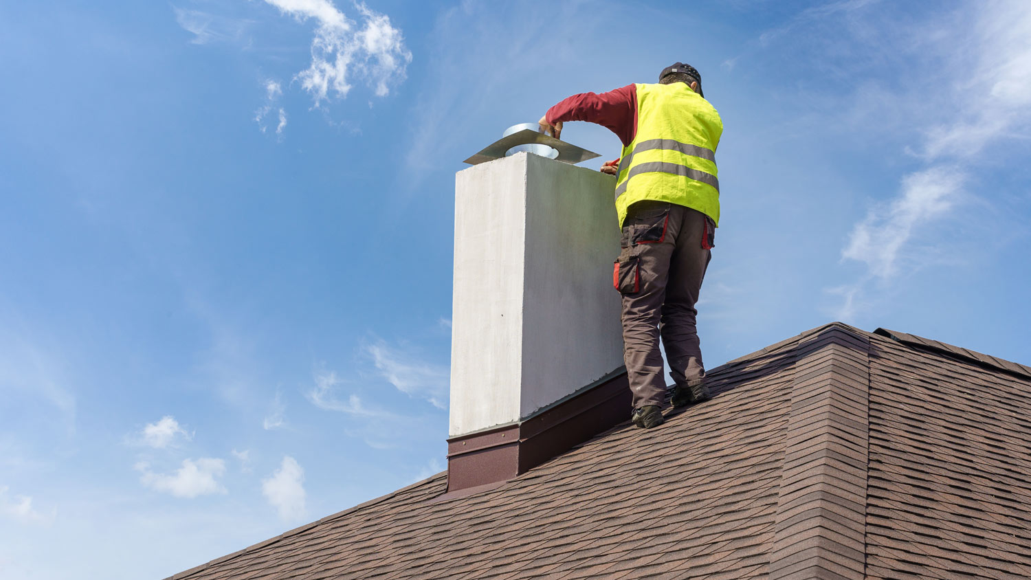 A professional sealing a chimney cap