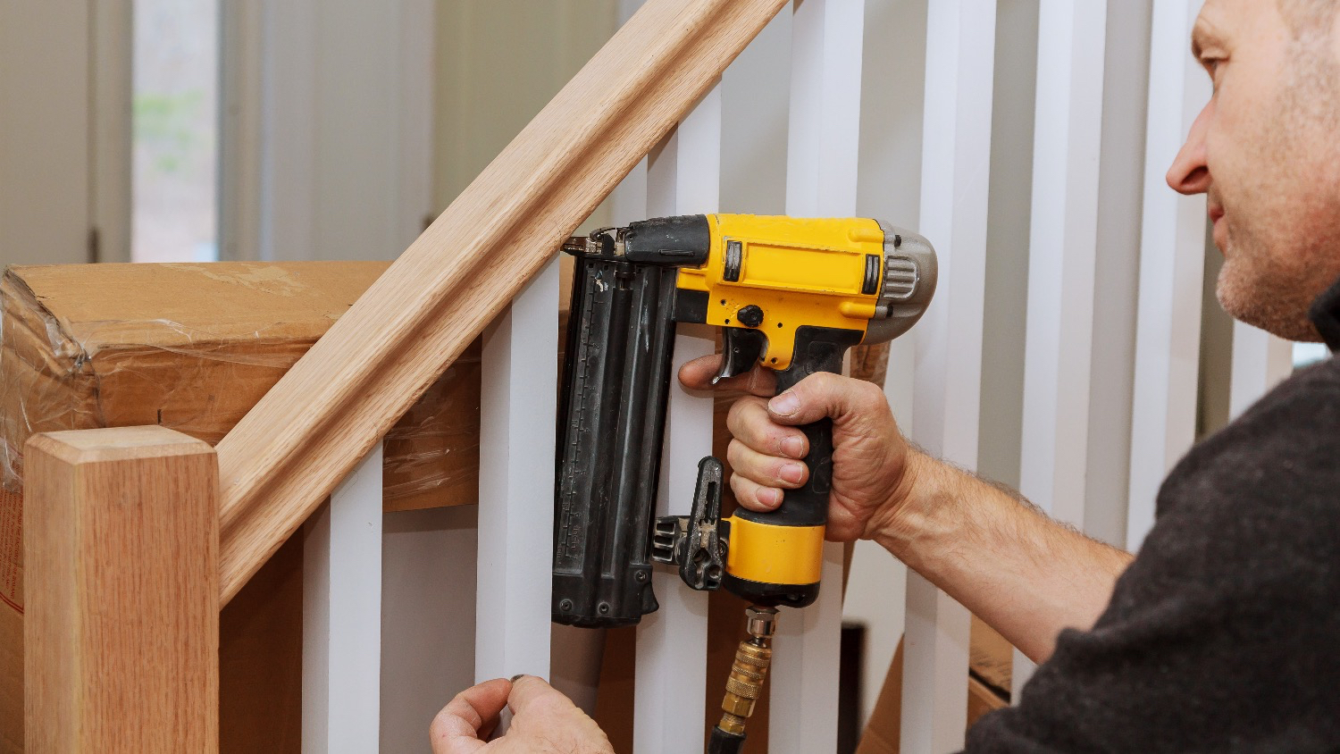 contractor installing stair railing in home