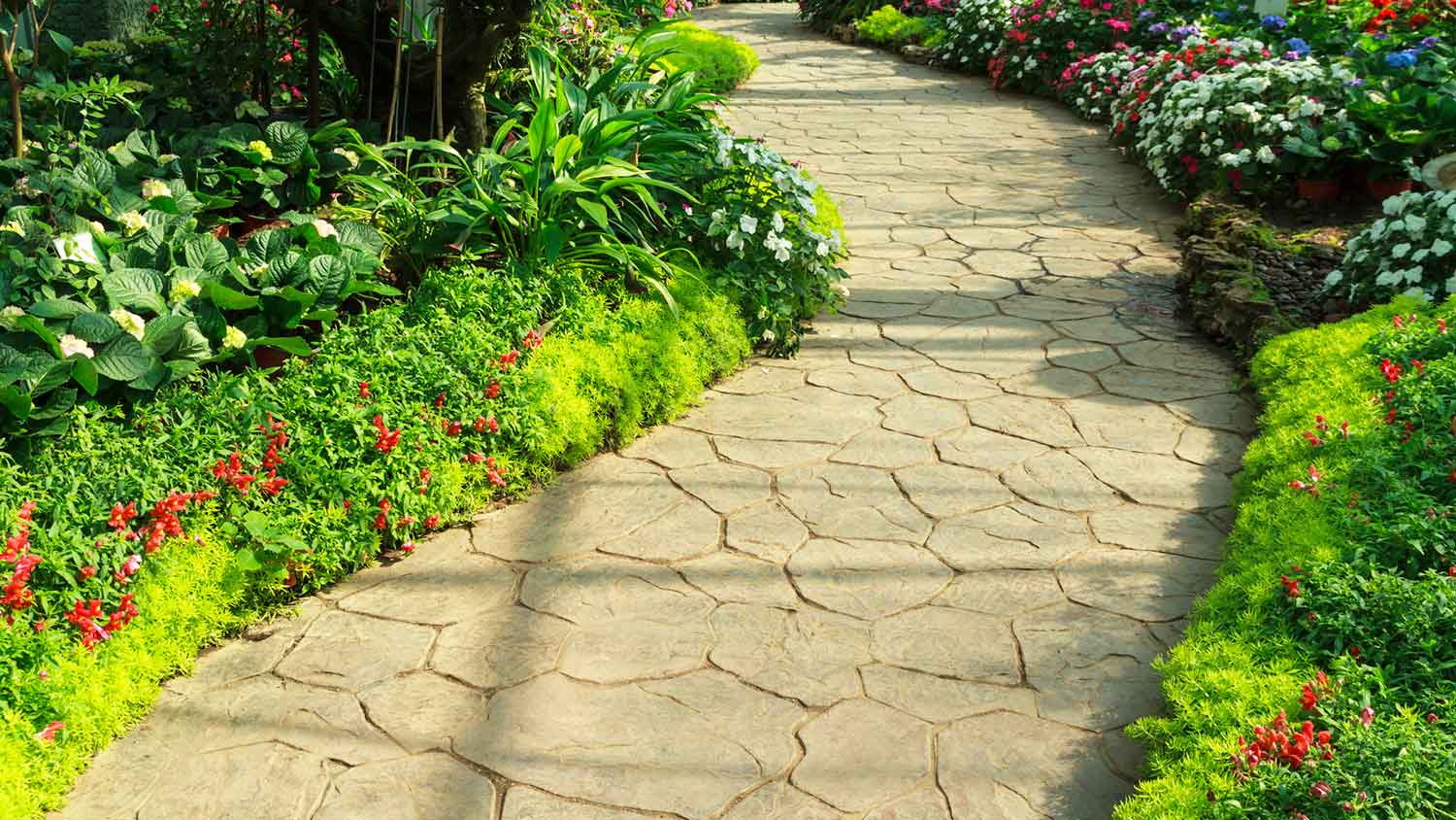 Stamped concrete walkway in a flower garden
