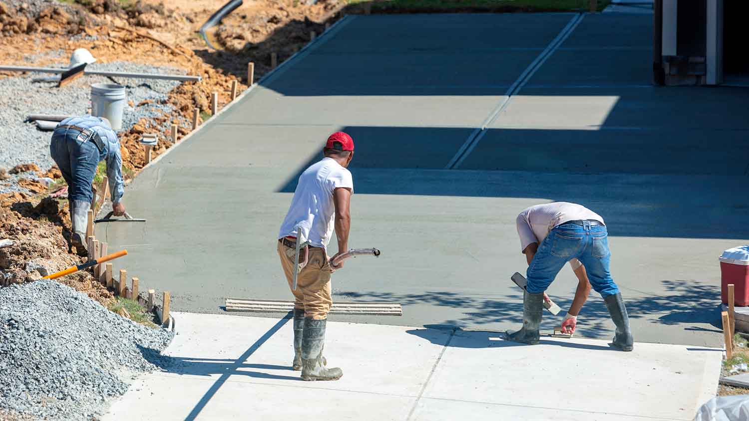 Professional workers pouring new concrete driveway