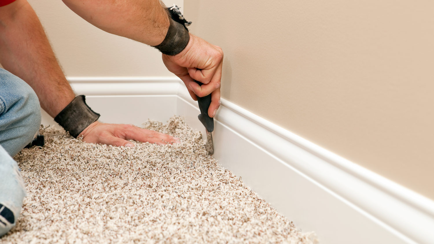 Detail of a professional installing carpeting flooring