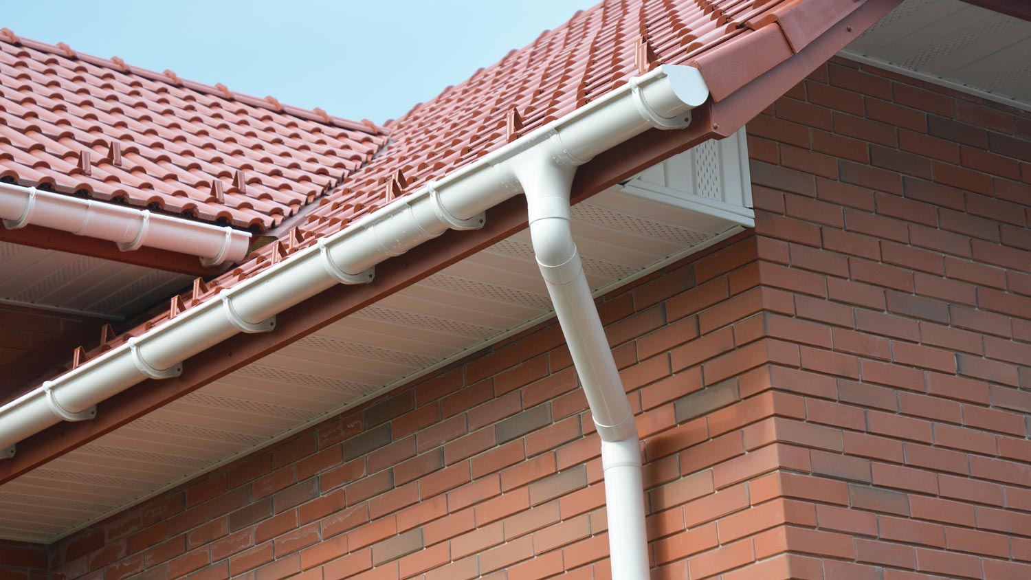 White painted gutters in a brick house