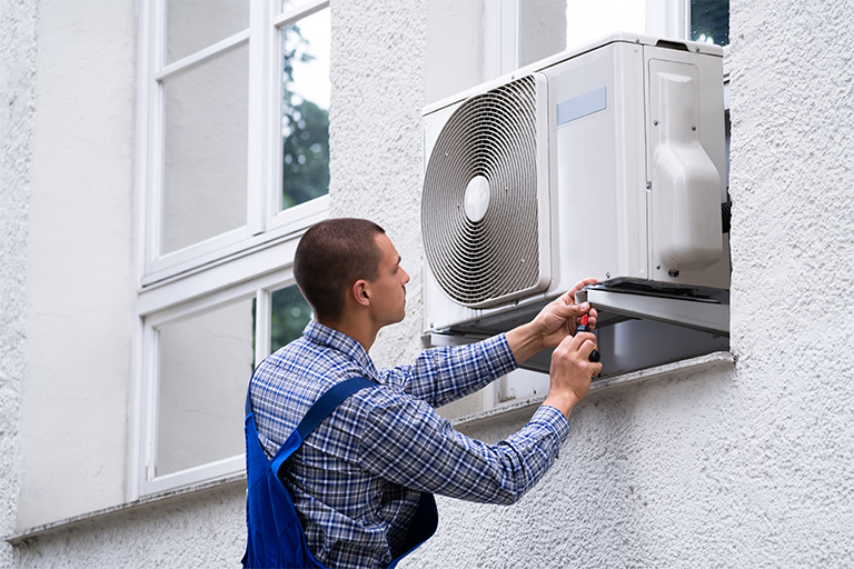 Professional repairing window air conditioner from outside