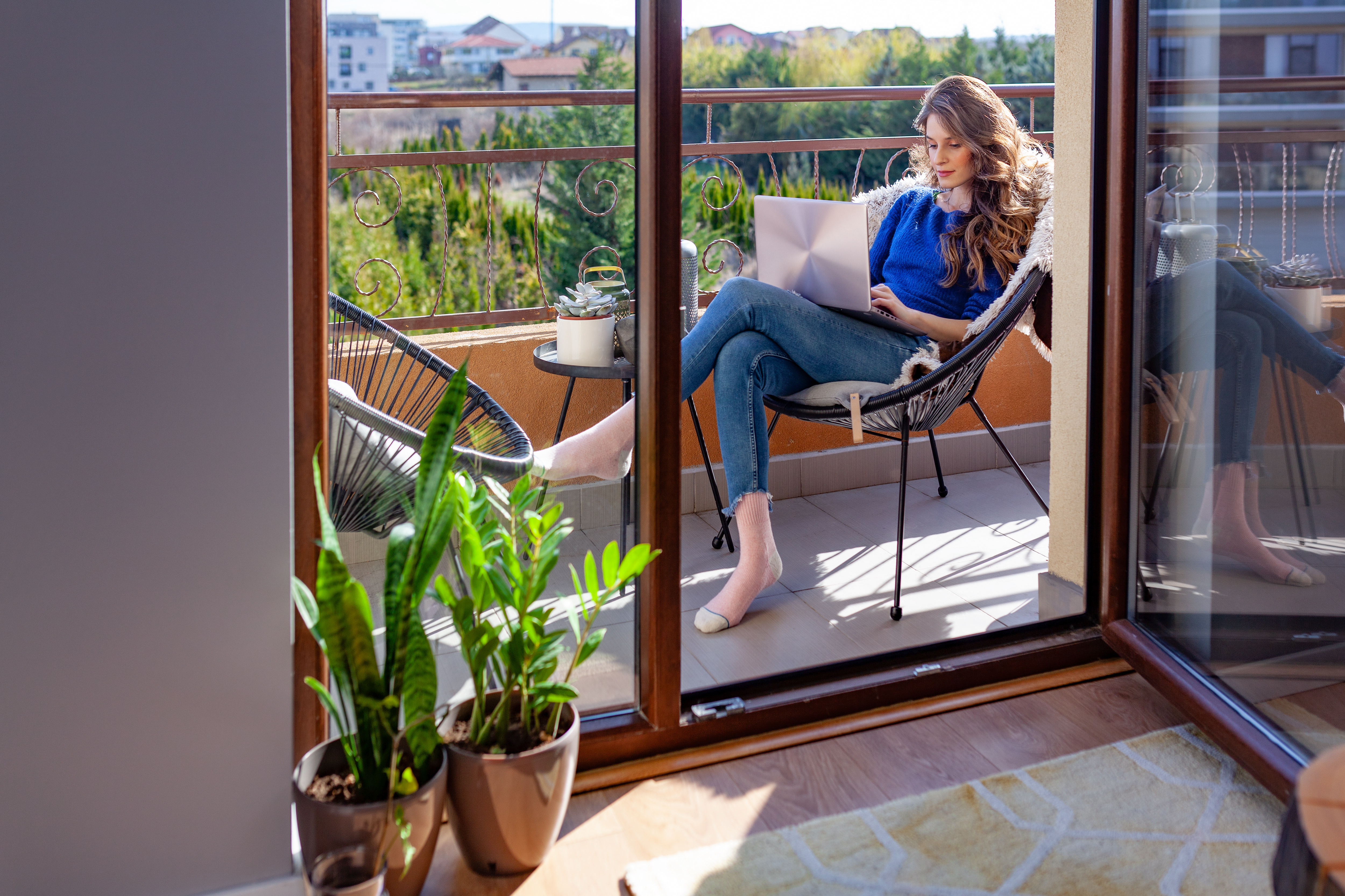 Woman working on computer on balcony