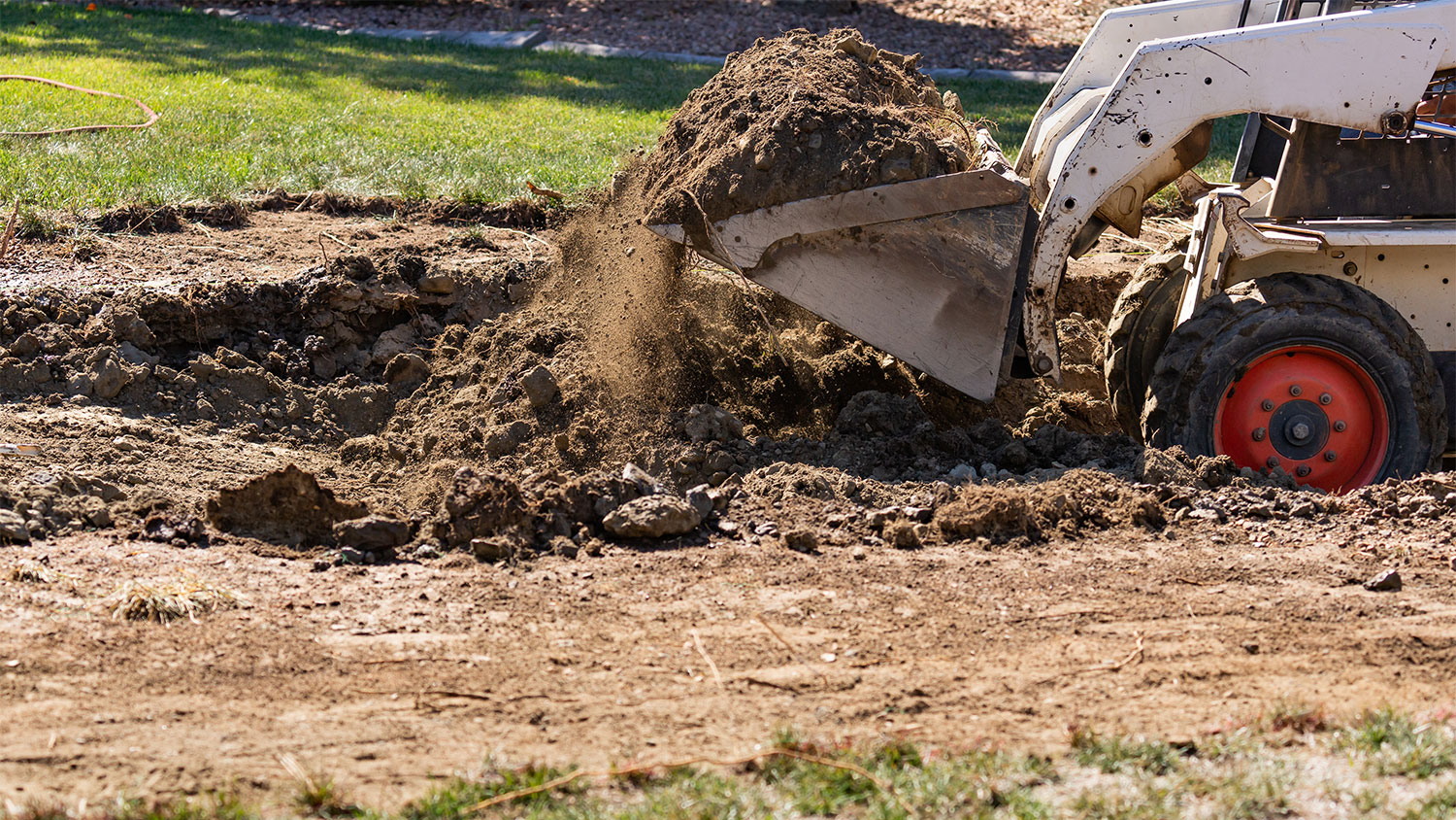 small bulldozer digging up yard
