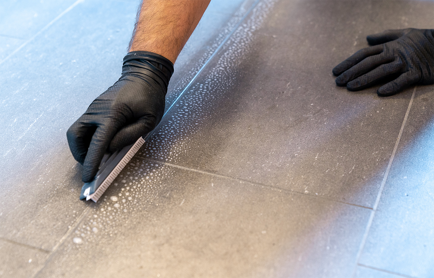Professional cleaning grout of floor tiles