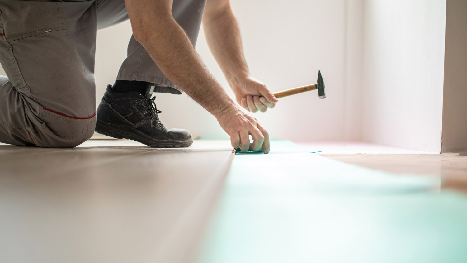 A man repairing a laminate flooring