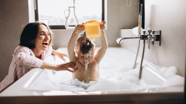 Mother and son playing in bathtub