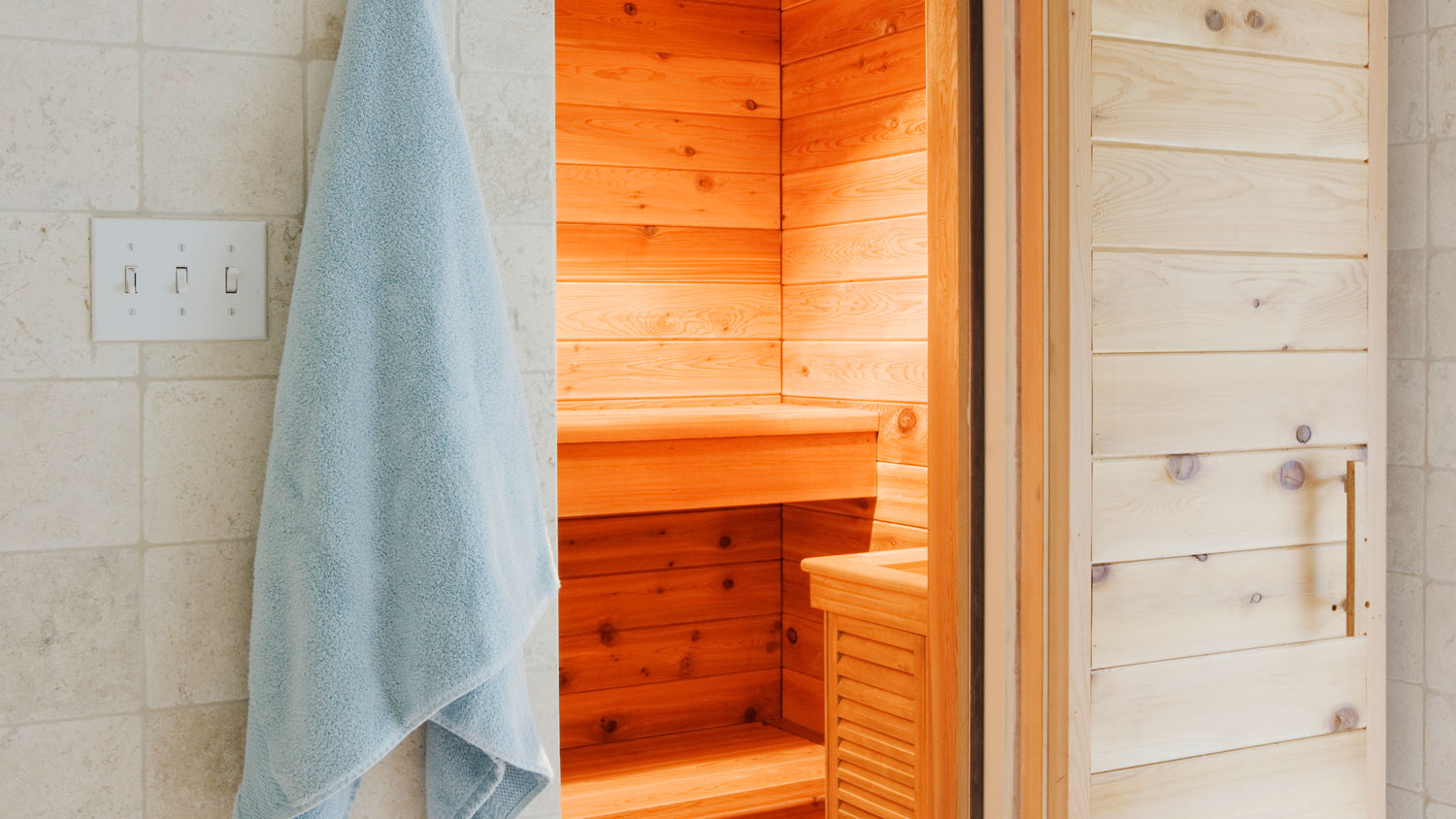 A steam room with a towel hanging from the door
