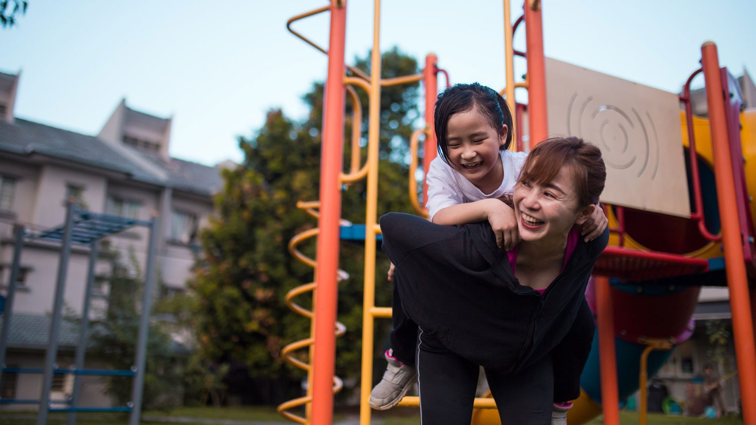 A mother with her daughter playing in the playground
