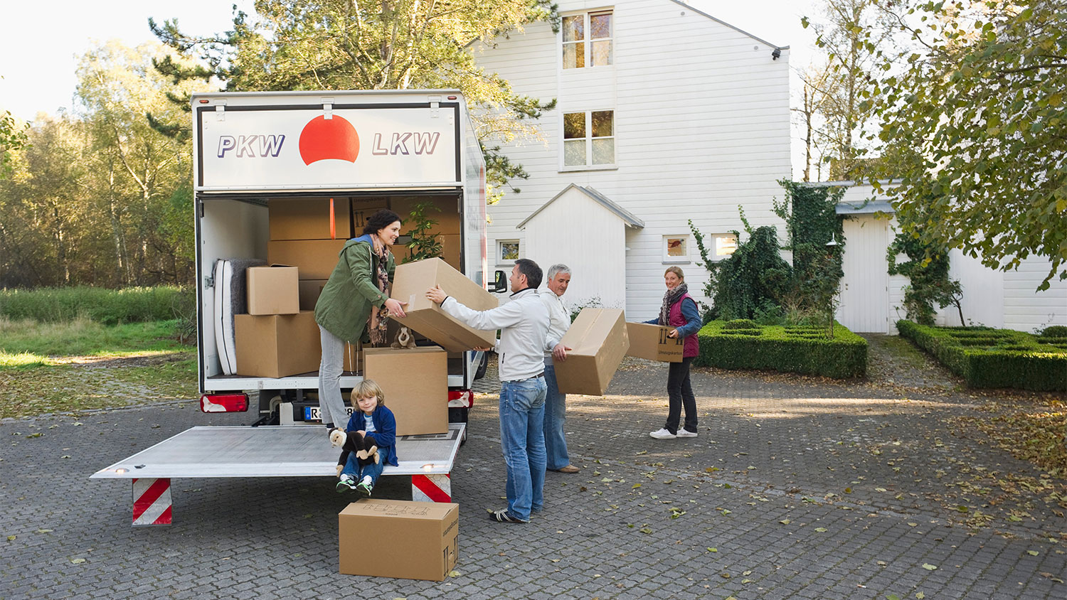 family loading boxes onto moving truck