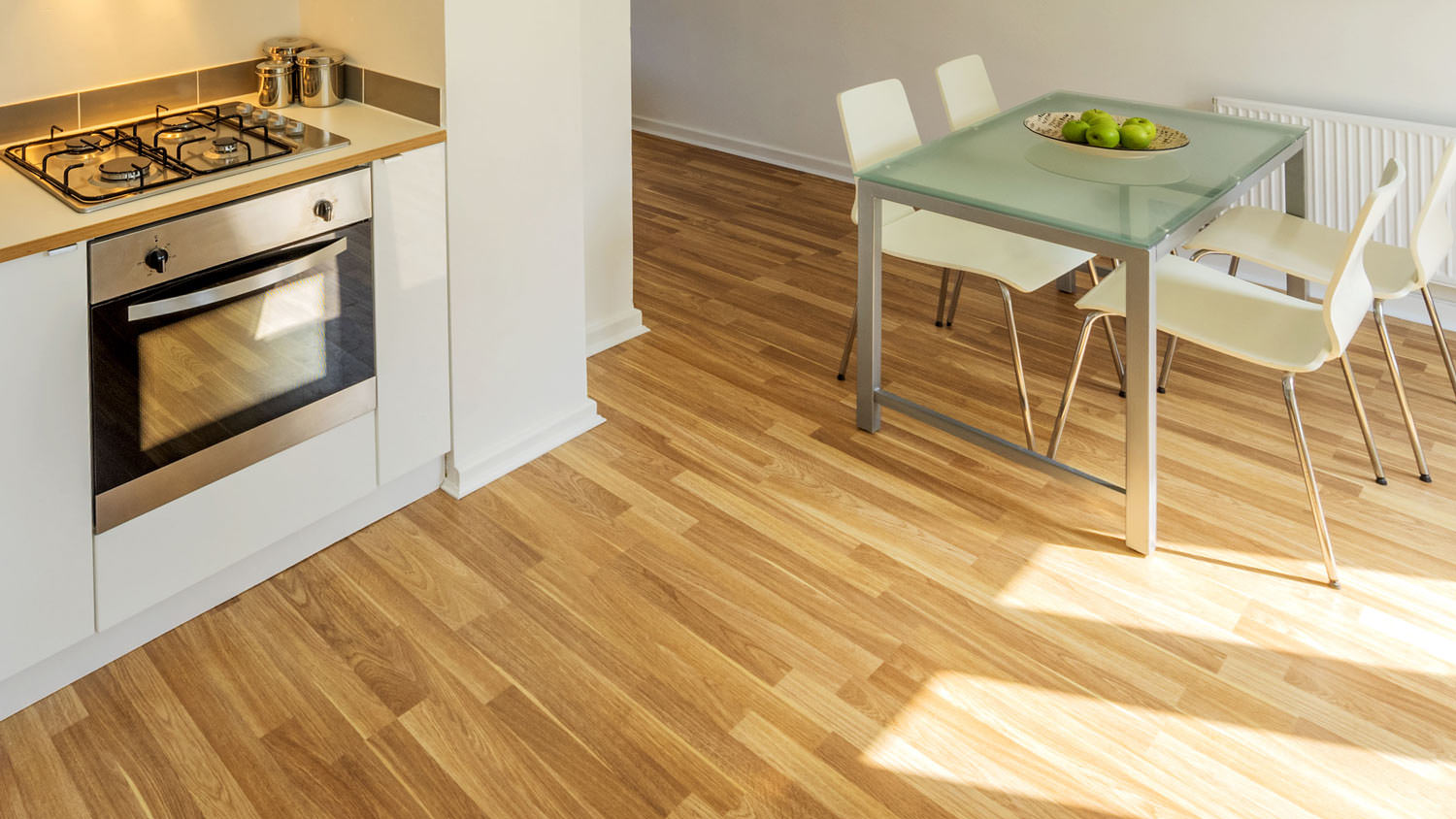 A sunlit laminate flooring in a kitchen