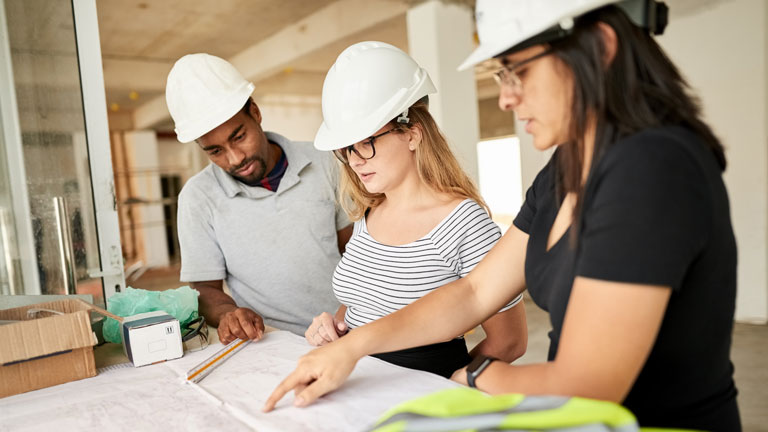 Three structural engineers going over plans