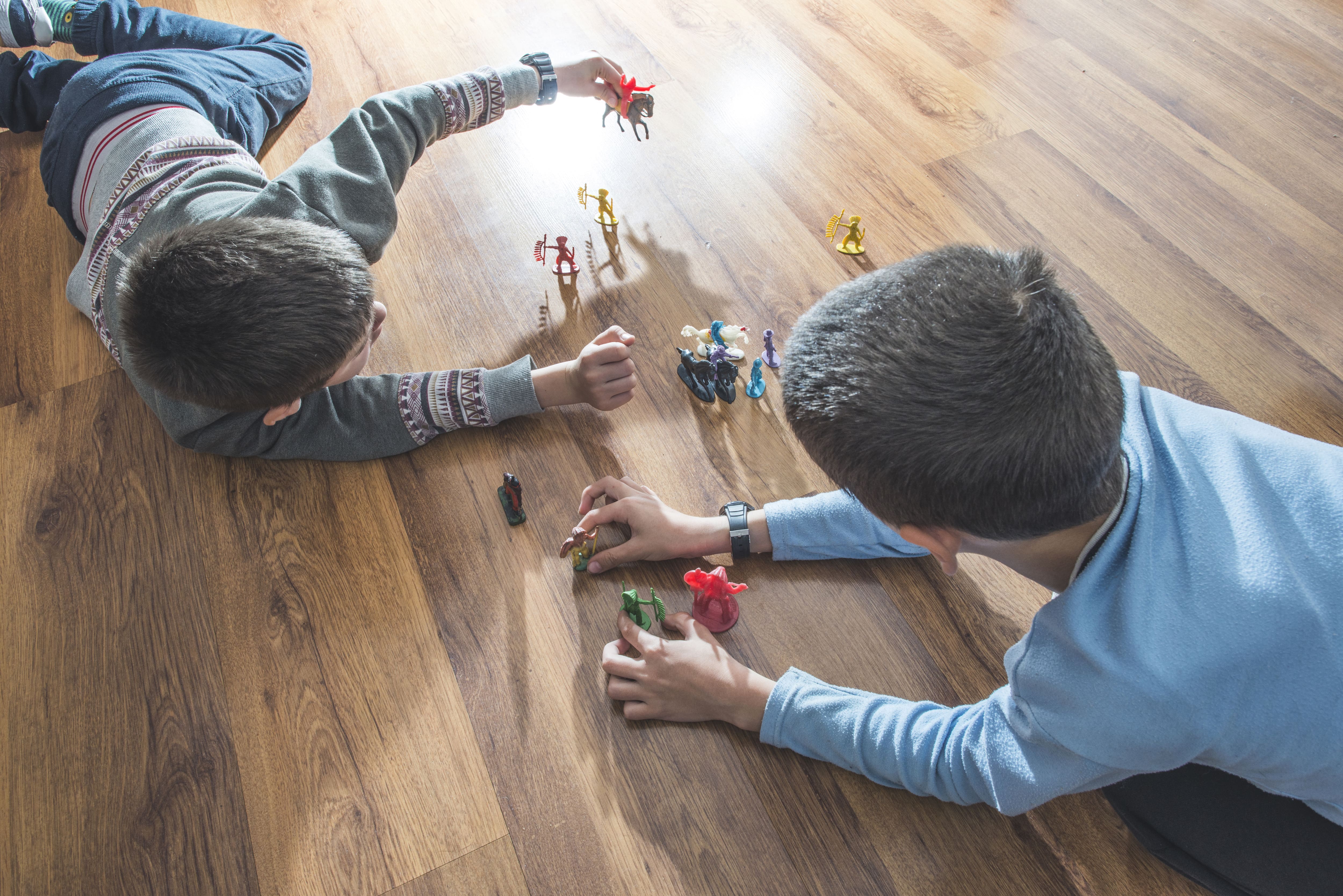 Boys playing with toys on vinyl flooring