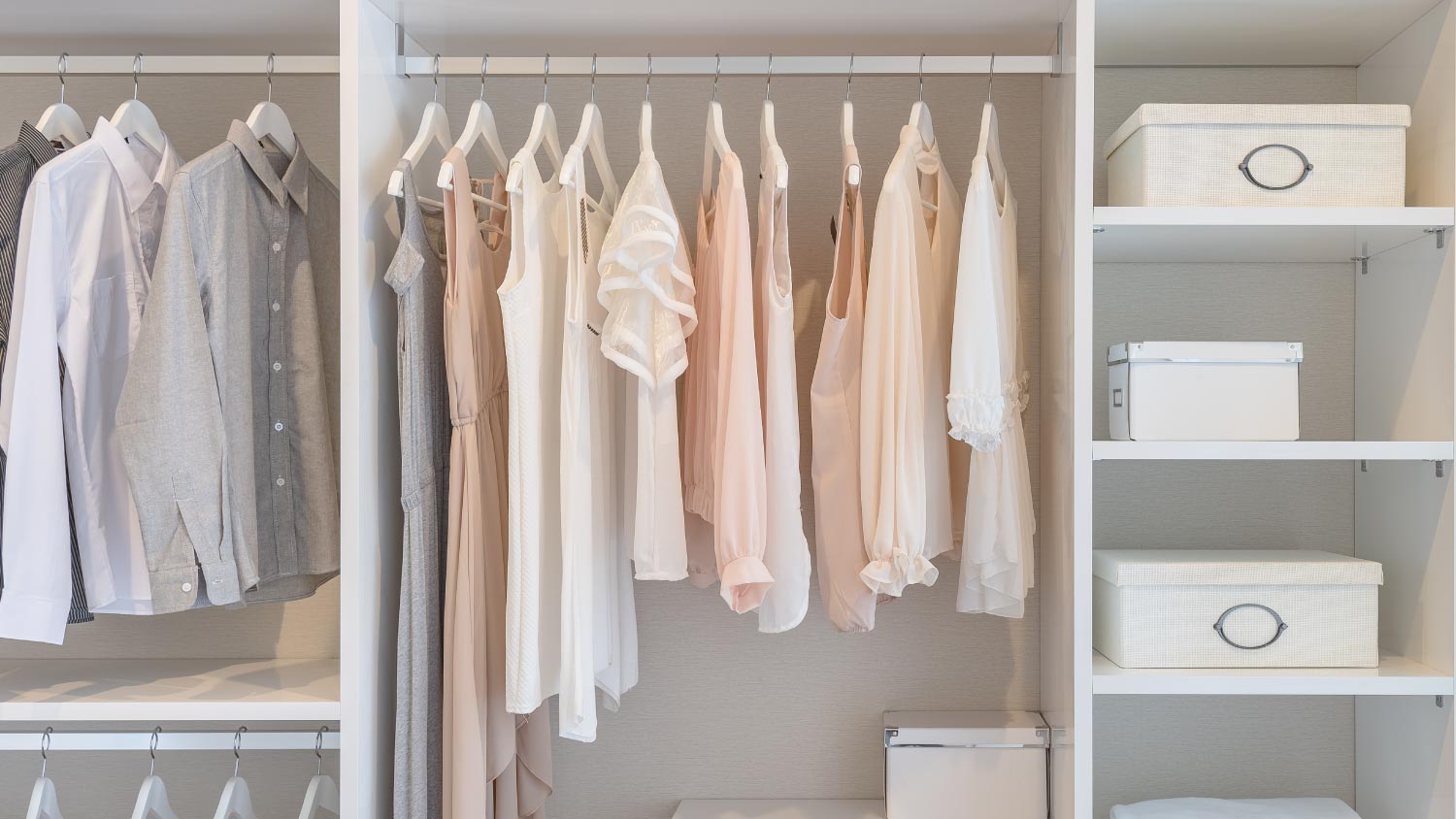 clothes hanging on rail in white wardrobe