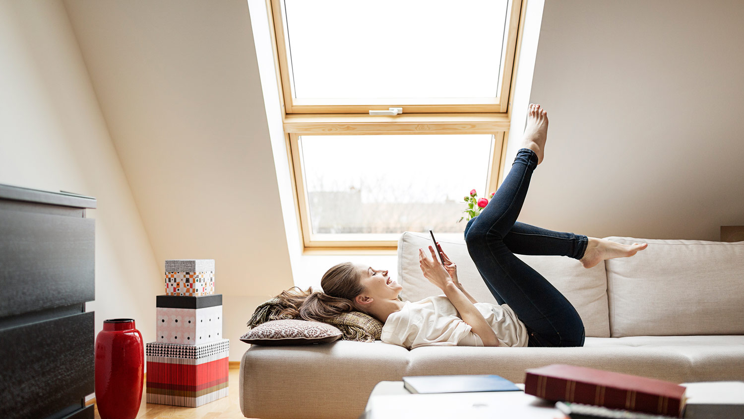 A woman relaxing in an attic with an egress window shining light