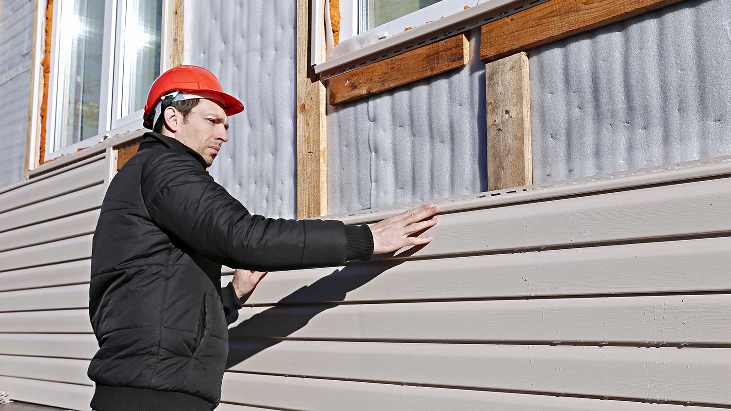 Worker installing house vinyl siding