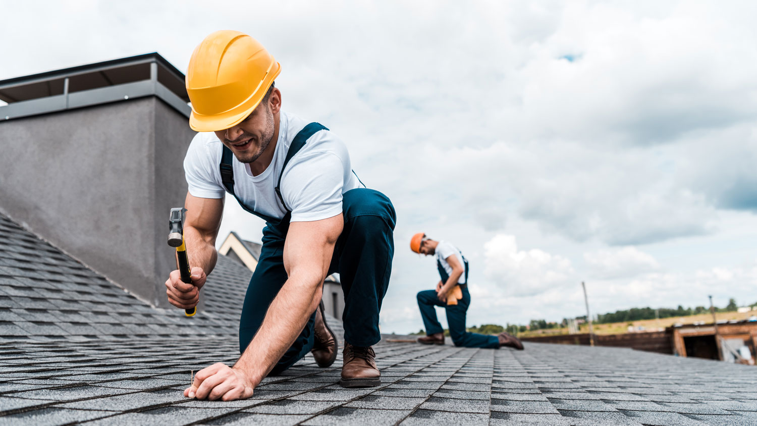 A roofer fixing a roof of a house