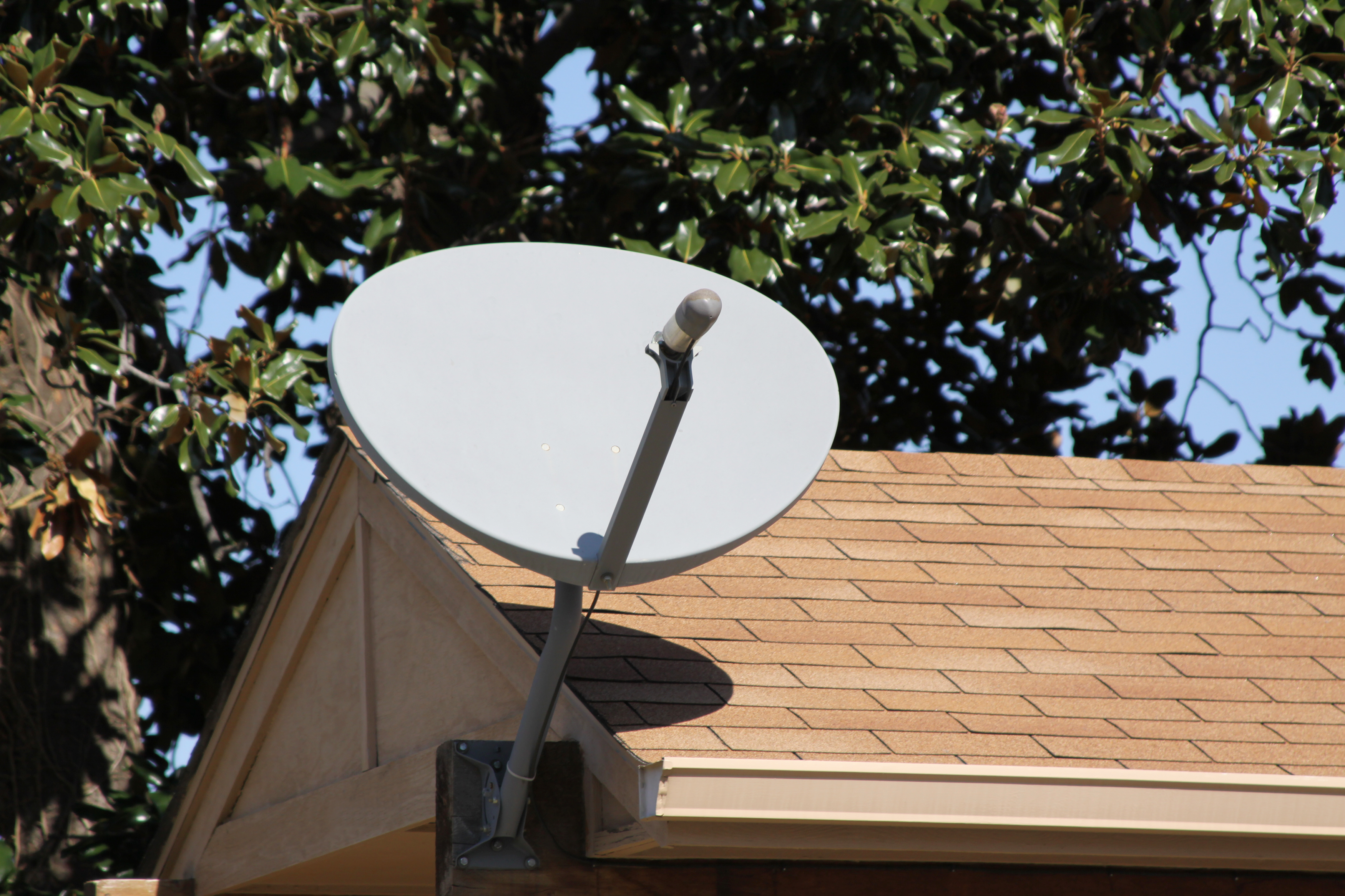 A satellite dish antenna on a rooftop is being installed or replaced for improved signal reception and connectivity