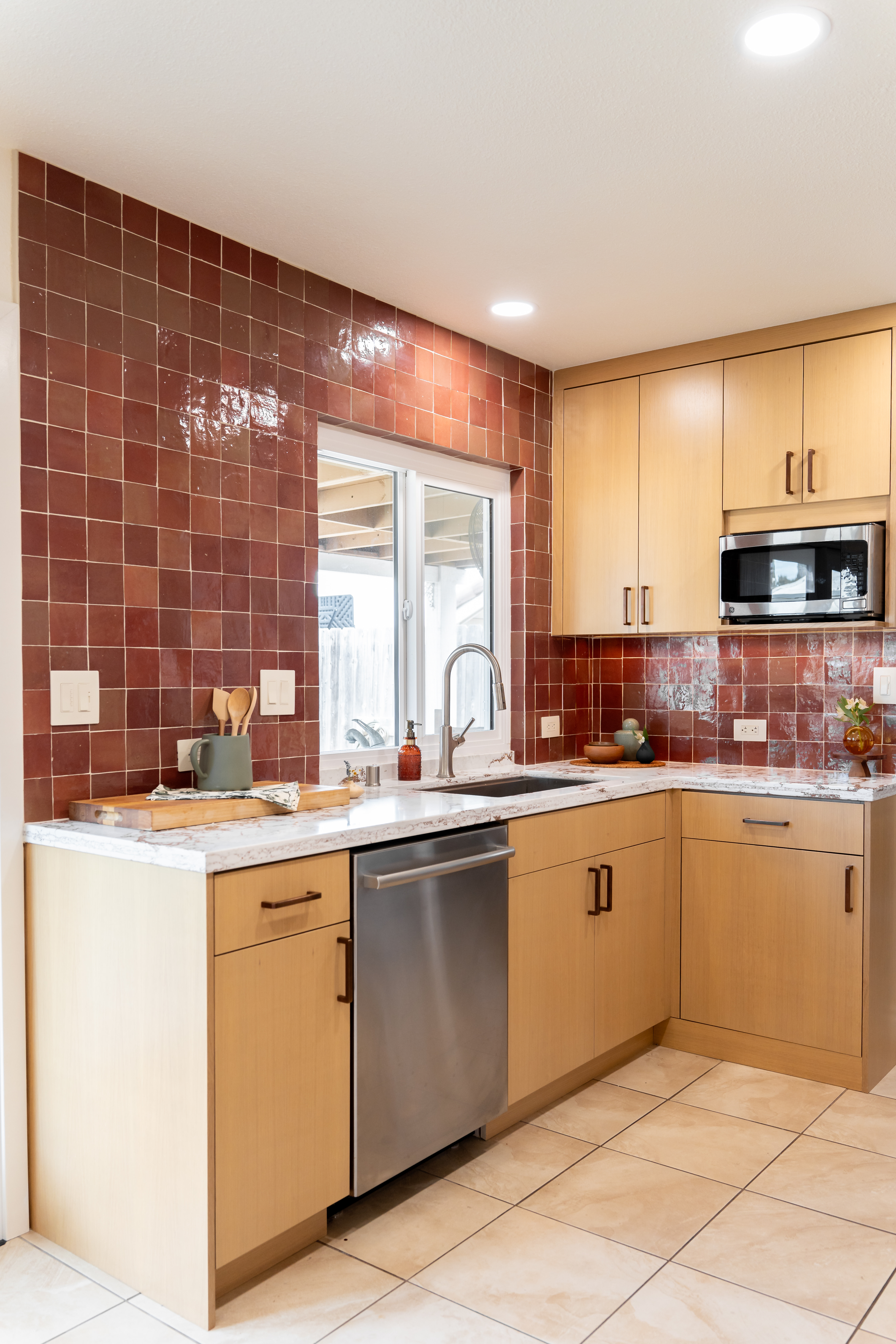 Completed kitchen removation with quartz countertop and tile backsplash