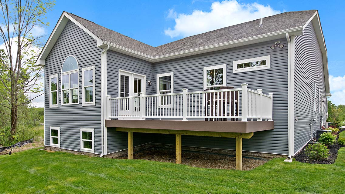 Raised backyard deck with white vinyl railing 