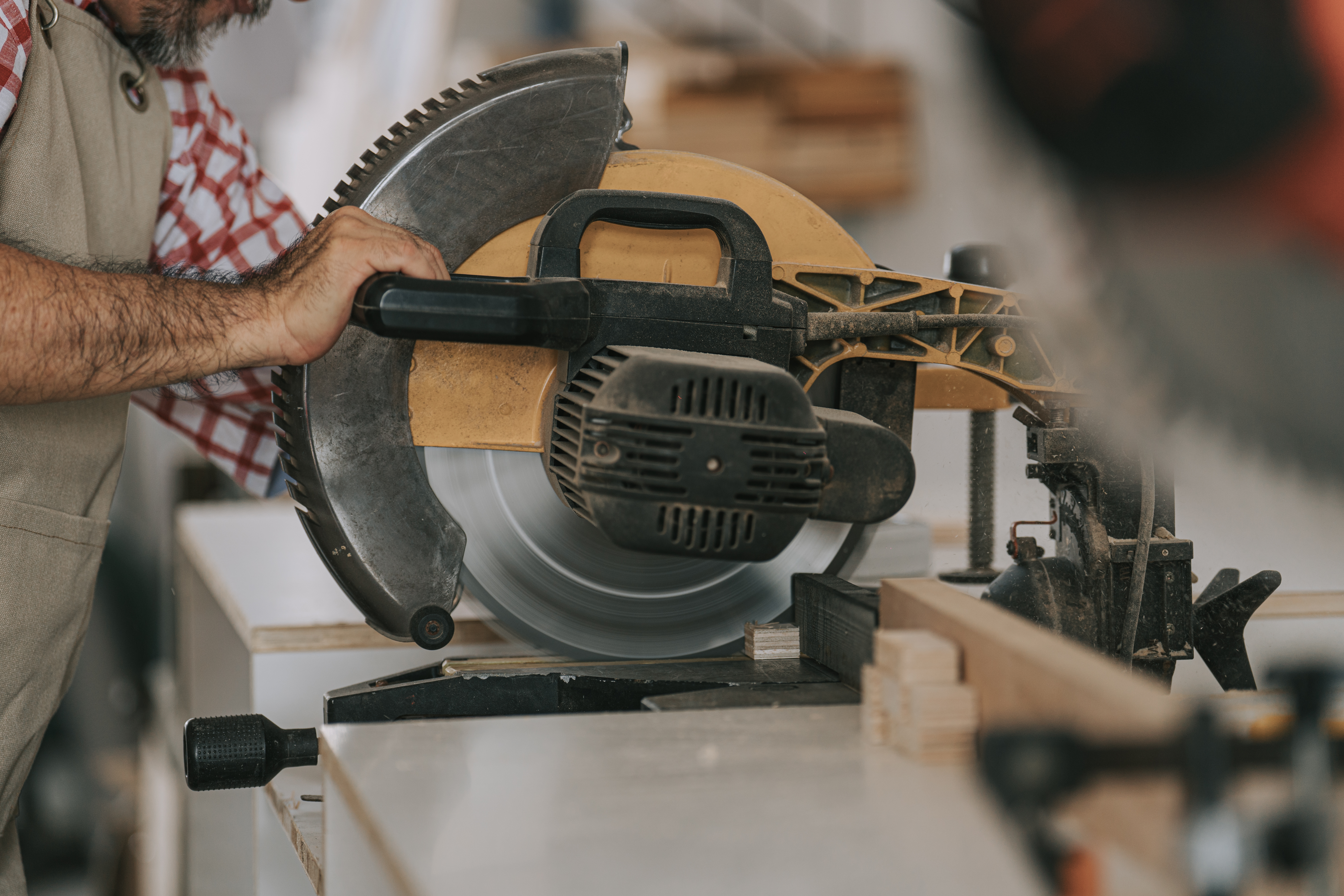 A man operating a miter saw 