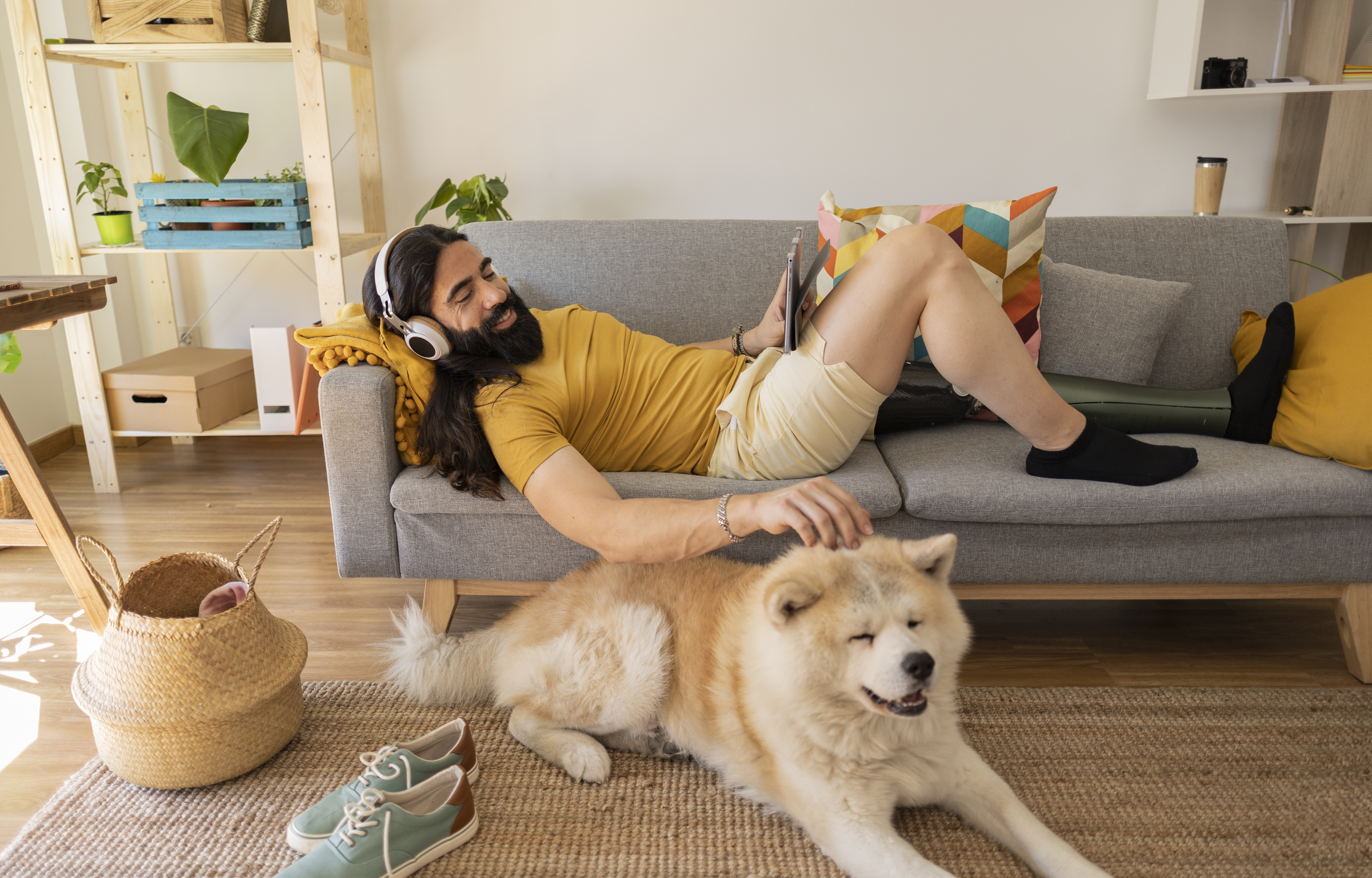 Man sitting on the couch and petting his dog
