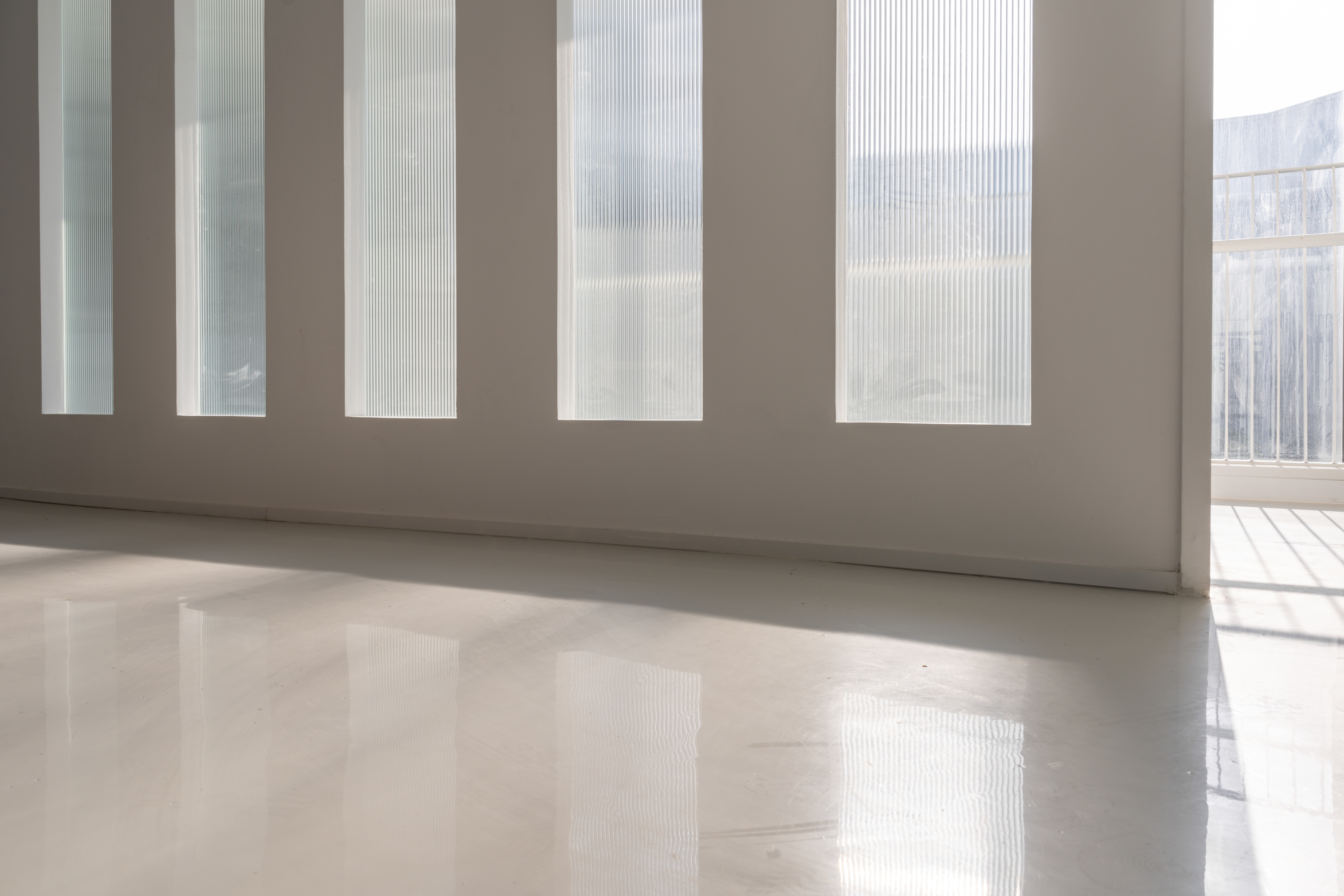 The sun shone through the room glass on the smooth ground