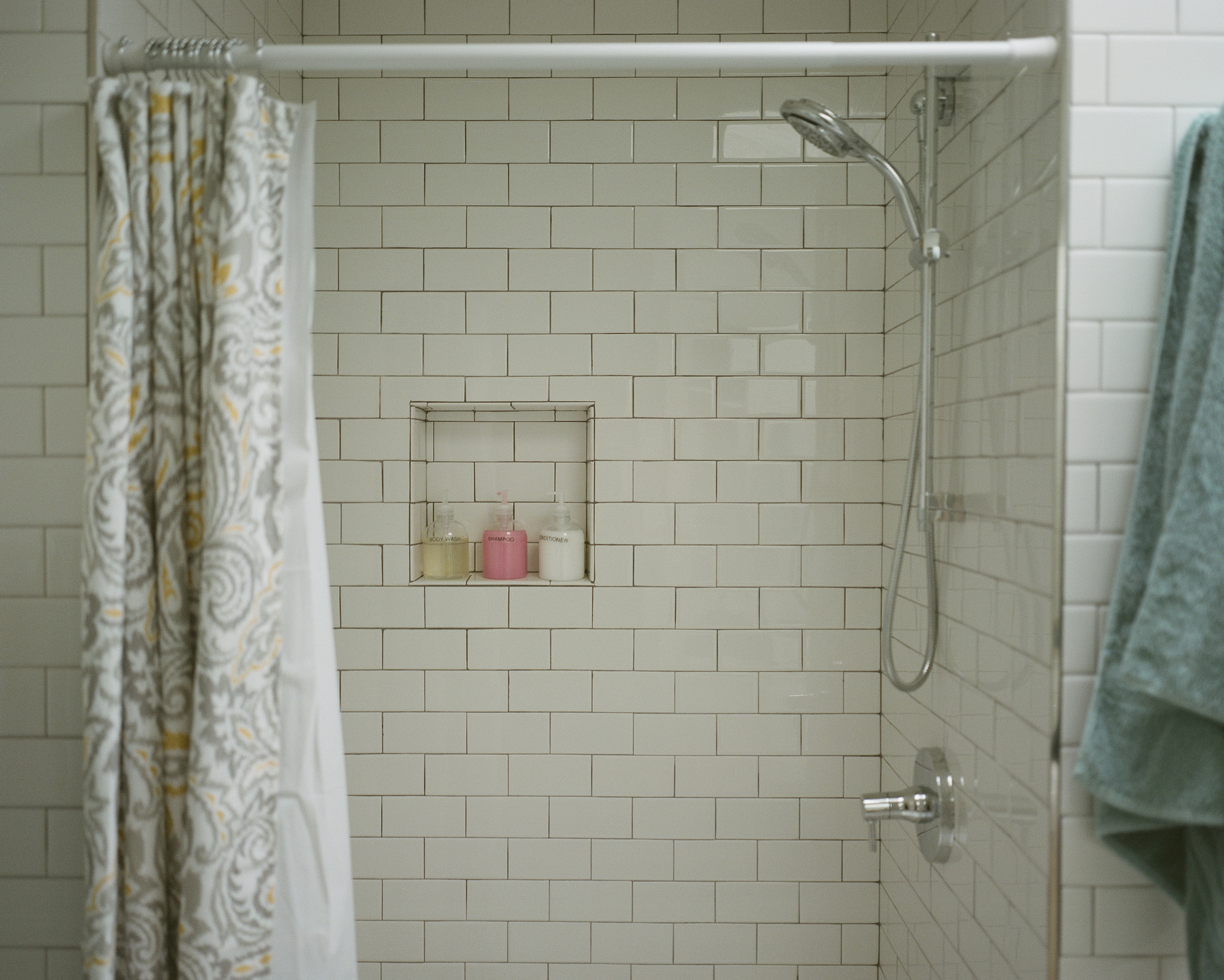 Tiled shower bathroom with green towel and soap