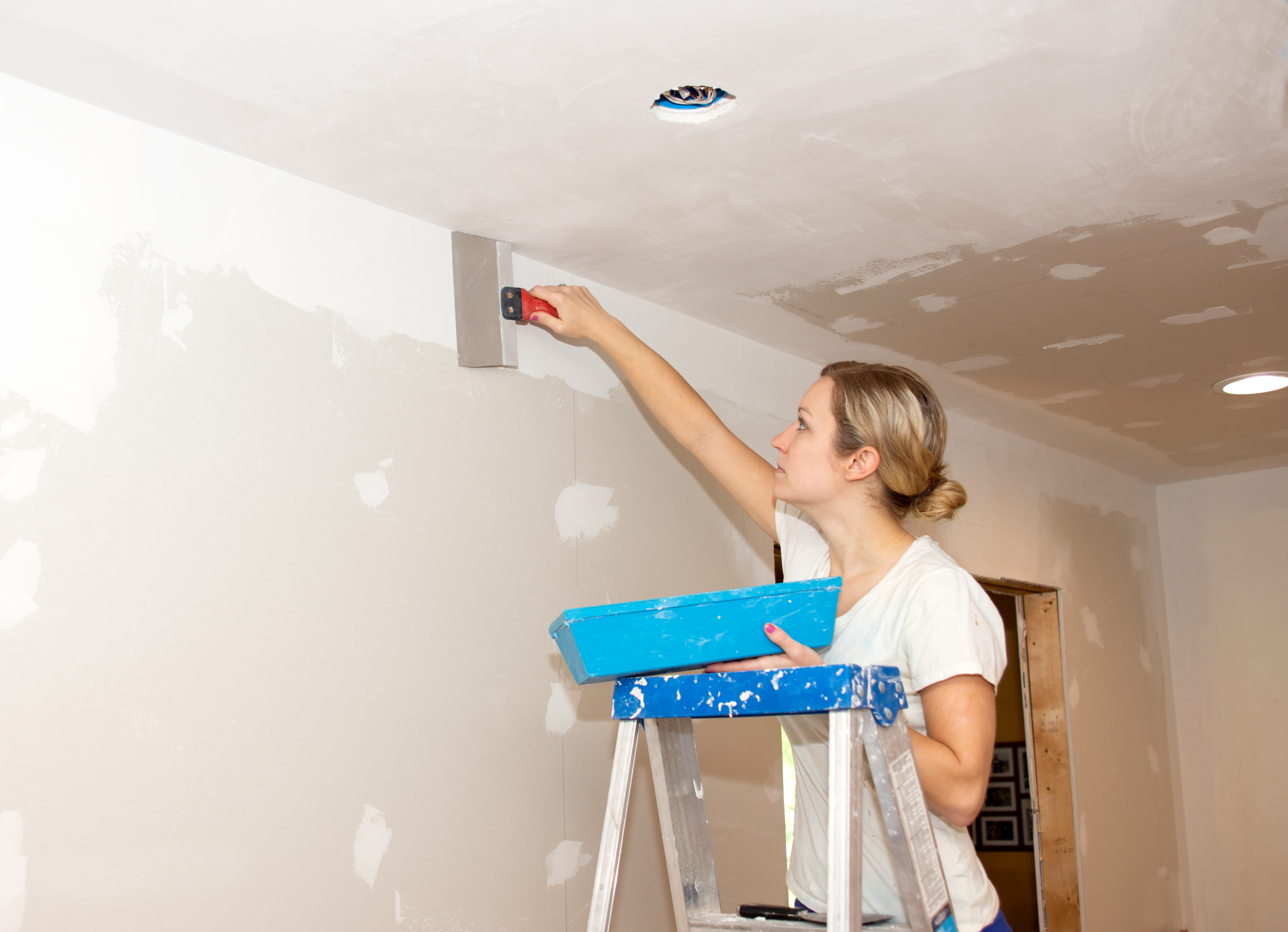 Woman applying joint compound 