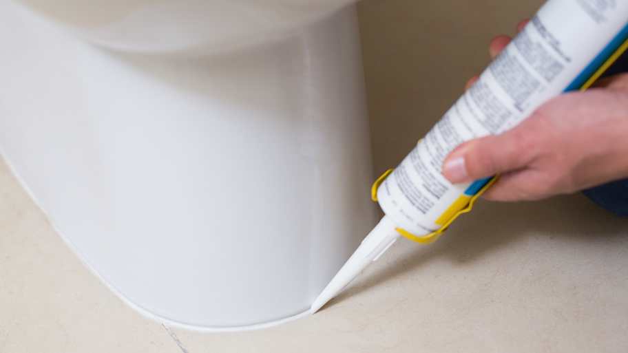 Plumber fixing toilet with silicone 