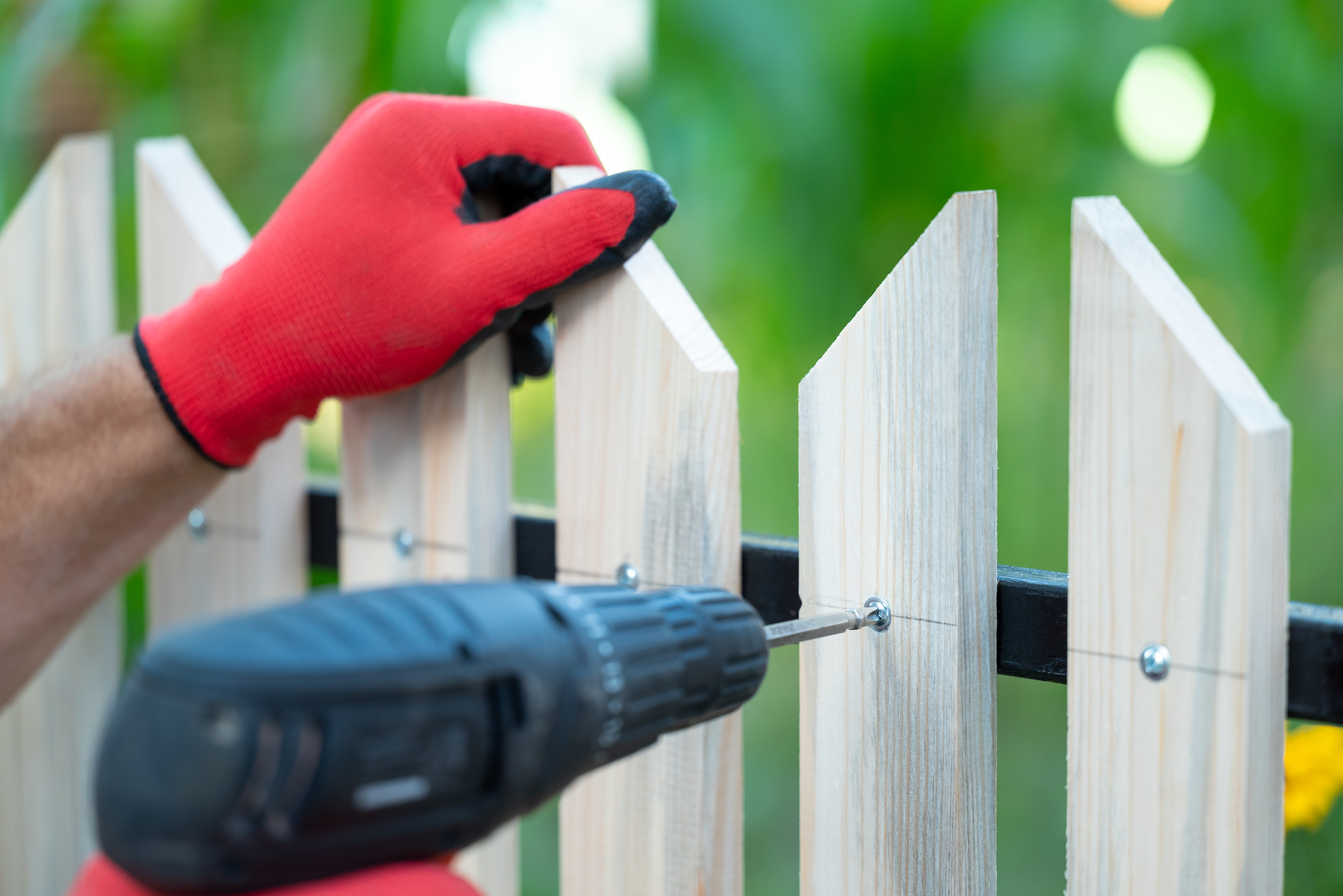 A person replacing a warped fence