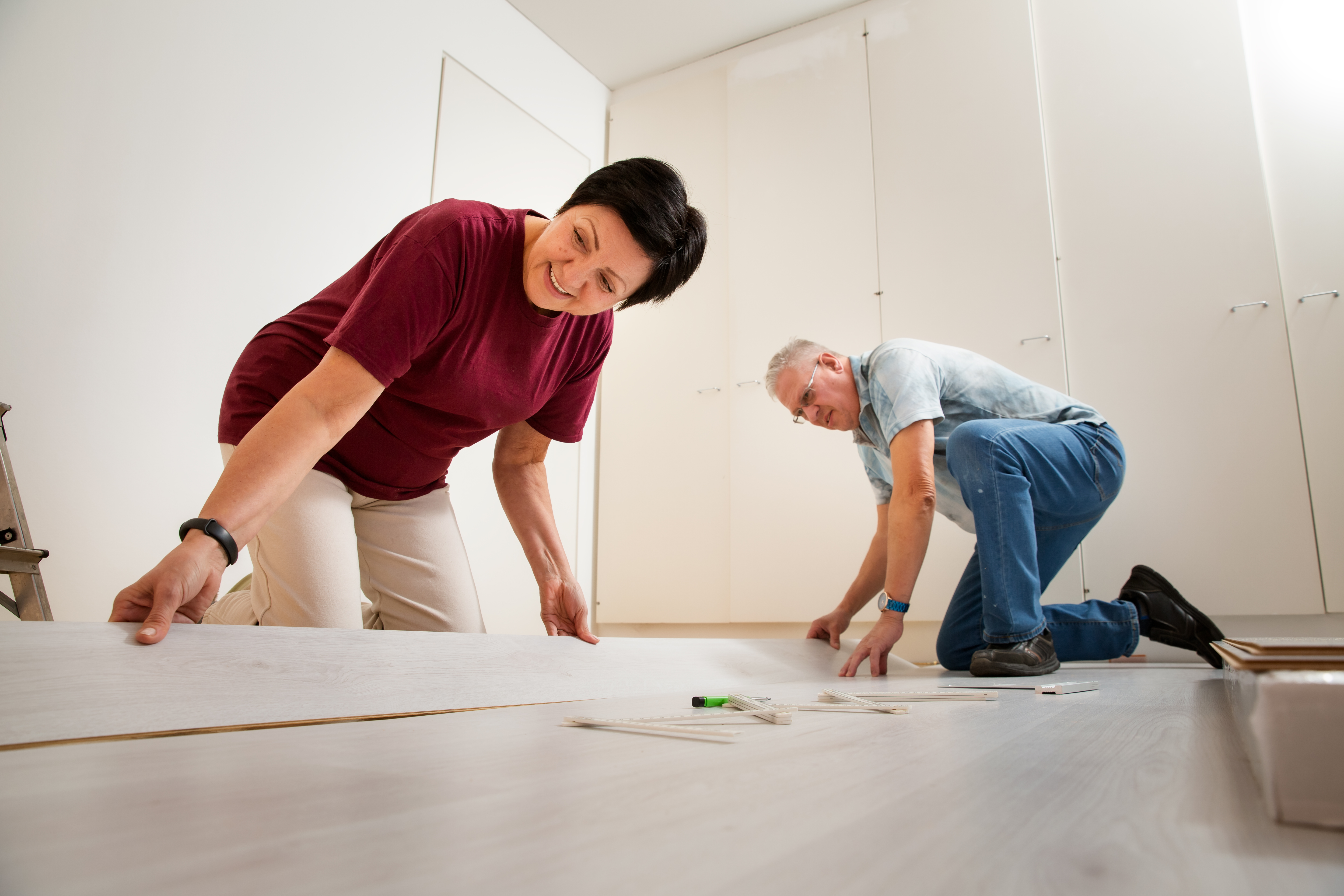 Couple installing laminate flooring in their new home together
