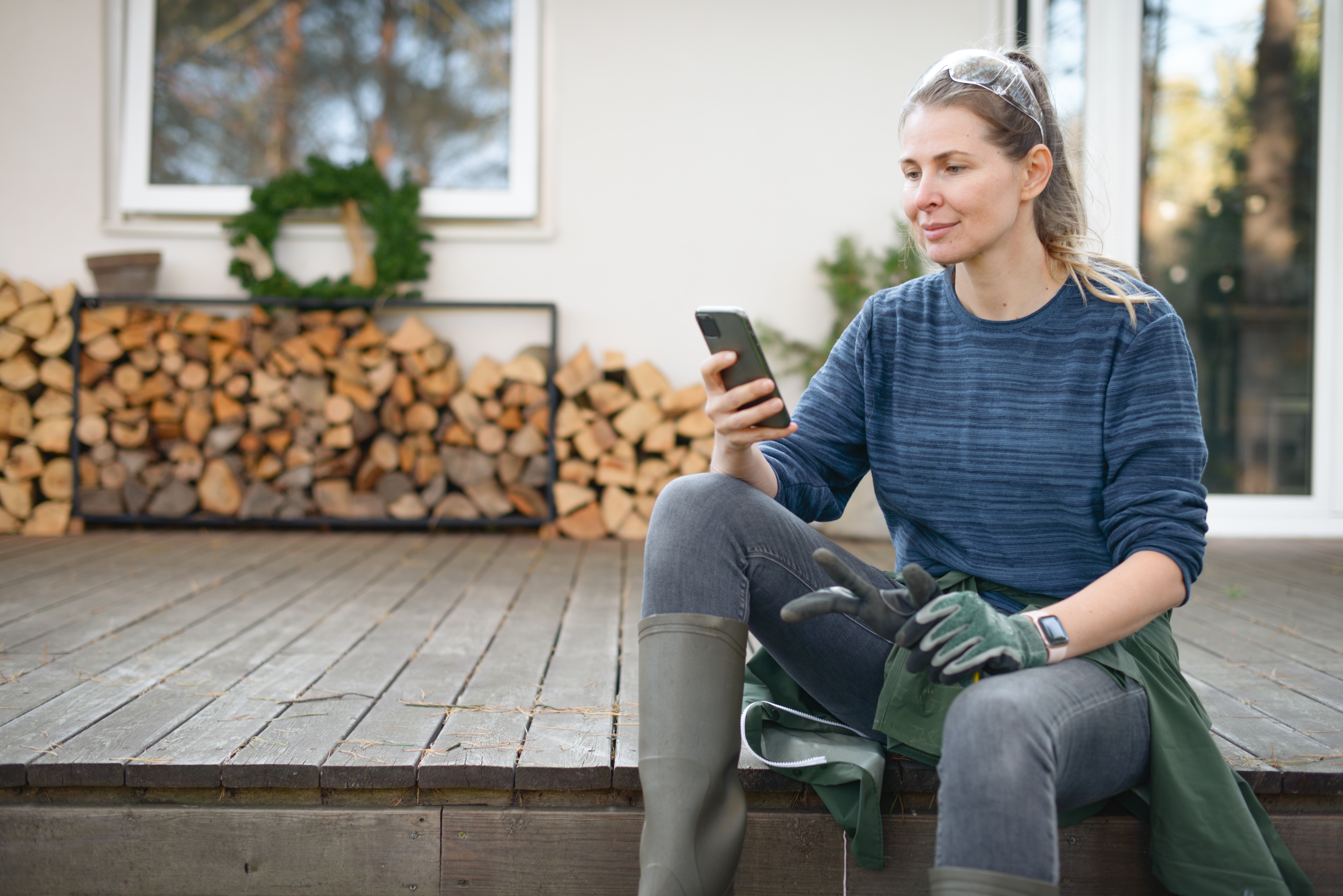 Woman working in the yard using a phone to check the weather forecast