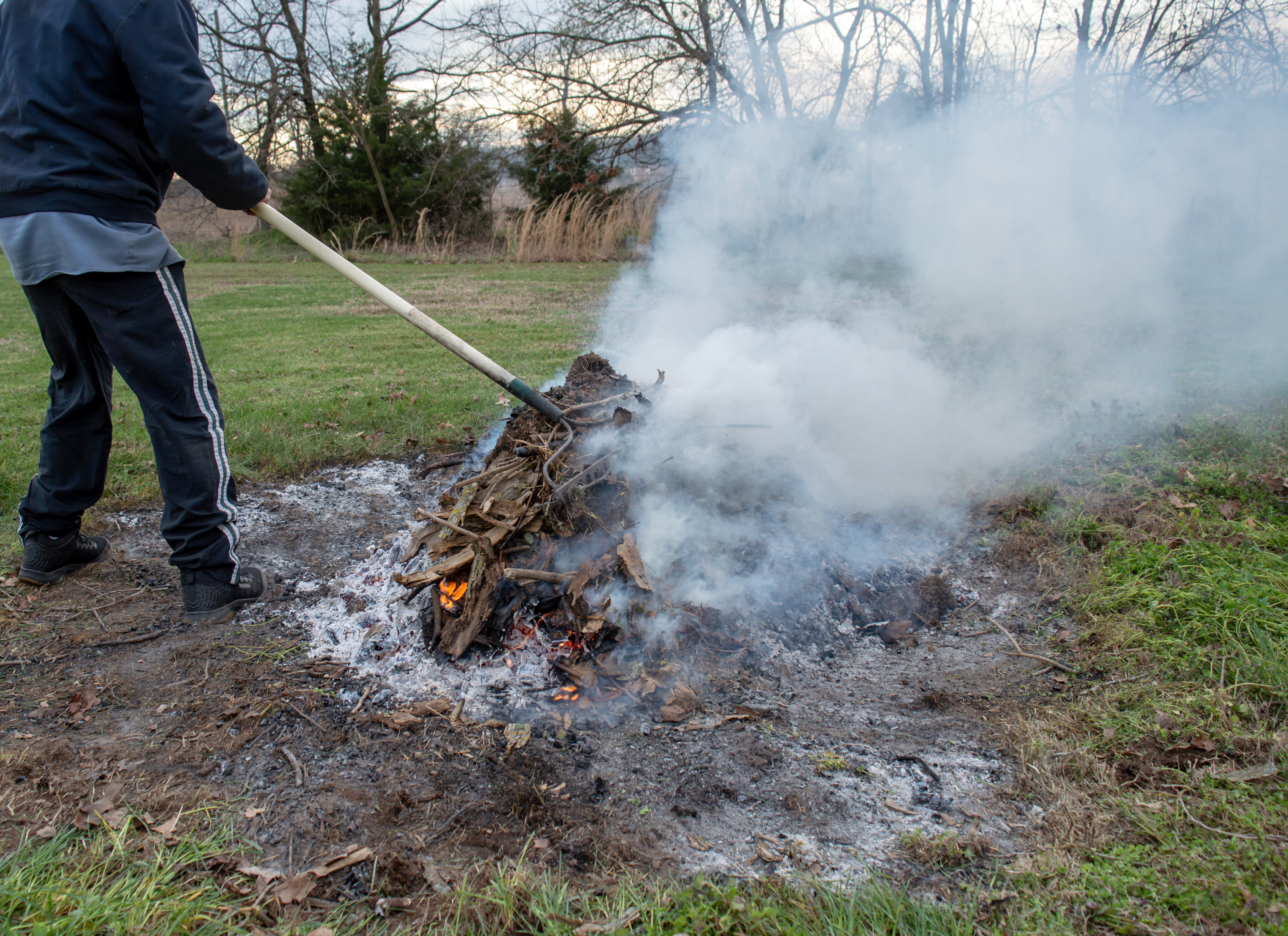 Person managing a fire pit in the yard